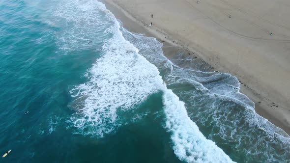 Gliding over the ocean towards the sand in Surf City USA California at sunrise as people enjoy their