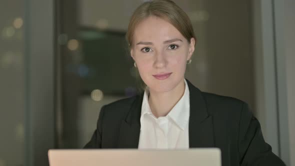 Close Up of Businesswoman Smiling in Office at Night