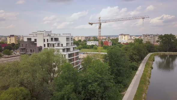 Aerial view of tower crane and residential building under construction.