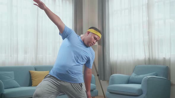 Fat Asian Man Doing Yoga By Reverse Warrior On Mat  At Home