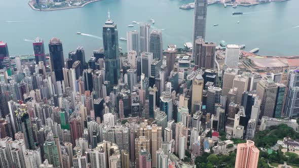 Tilt up aerial view of Victoria Harbour, Hong Kong during the day with beautiful rain clouds.