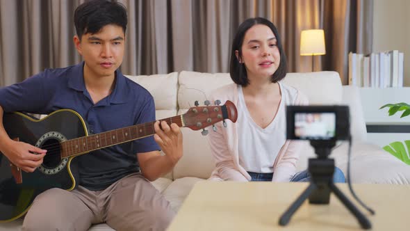 Young influencers sing a song and playing guitar, showing on live streaming or online broadcasting.