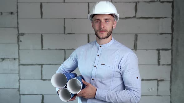 Construction engineer with blueprints in hands