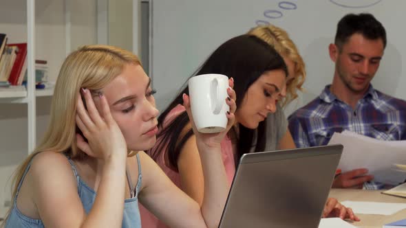 Young Businesswoman Looking Tired While Working with Her Team