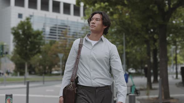 Asian Businessman with Suitcase Walking on City Street