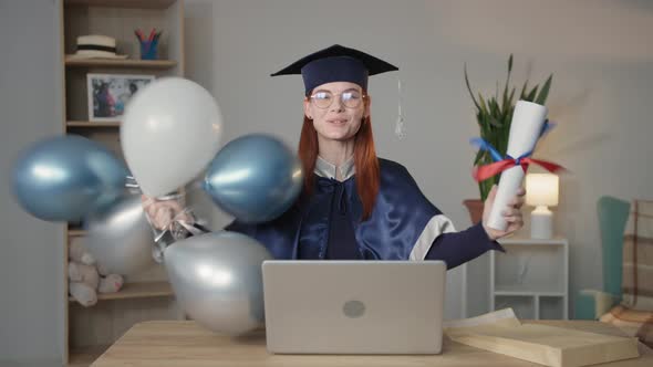 Modern Learning Happy Female Student in Mantle and Hat Rejoices at University Diploma with Balloons