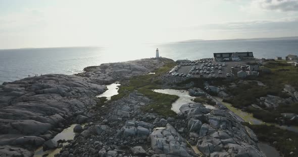 Stony seashore with lighthouse and parking lot