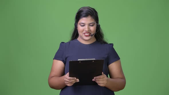 Young Overweight Beautiful Indian Businesswoman Against Green Background