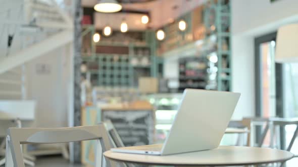 Young Woman Open Laptop on Top of Table in Cafe