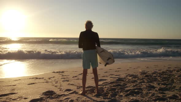 Senior man with surfboard at the beach