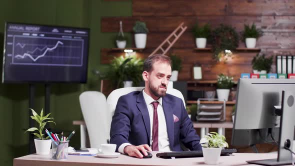 Office Worker Alone at Work Raises His Hands Happily in the Air