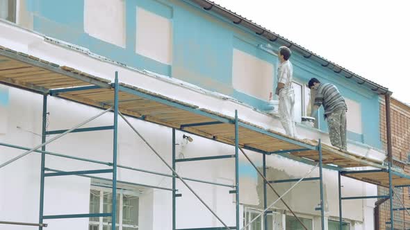 Workers Painting By Paintbrush Building Wall