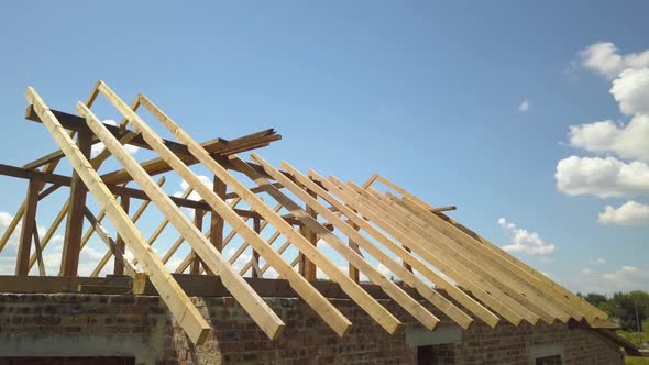 Aerial view of unfinished house with wooden roof frame structure under construction