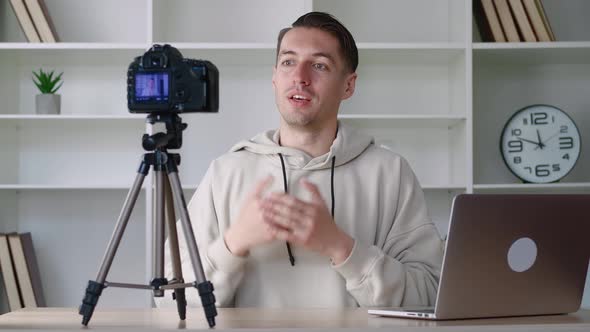 Young Blogger Man Filming New Vlog Video with Professional Camera at Workplace at Office