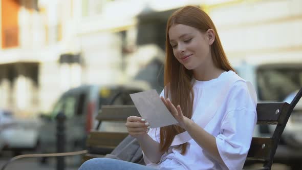 Happy Teenage Girl Admiring Photo of Boyfriend, Secretly Kissing It, Affection