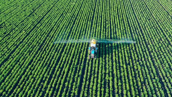 Top View of a Field Getting Fertilized By a Spraying Vehicle