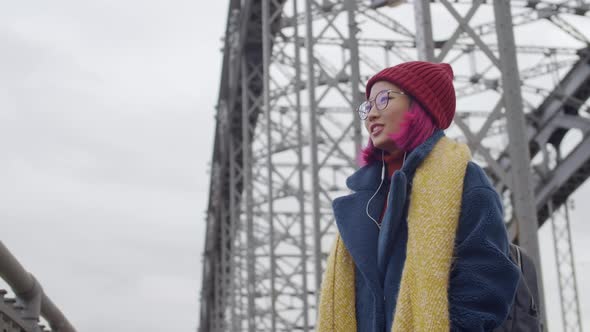 Cheerful Asian Female Tourist Enjoying City View from Bridge