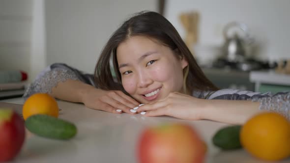 Closeup Portrait of Smiling Charming Asian Woman Posing in Kitchen Indoors