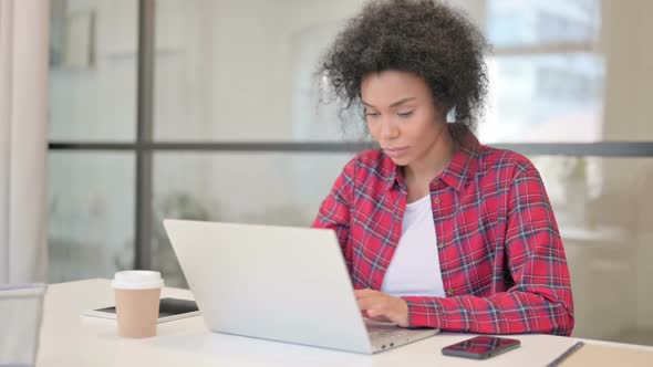 African Woman Celebrating Success While Using Laptop