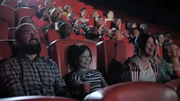 Happy Family Enjoying Comedy in Movie Theater