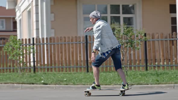 Senior Hipster Learning to Ride a Skateboard