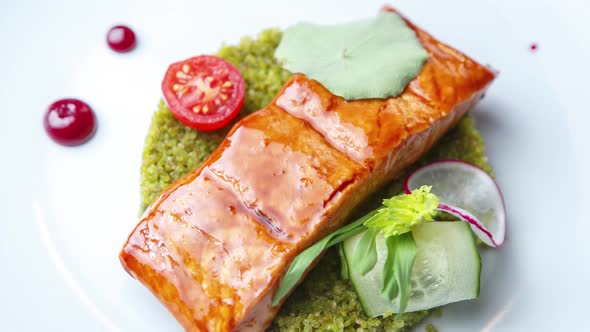 Red fish fillet served with exotic green couscous garnish in seafood restaurant