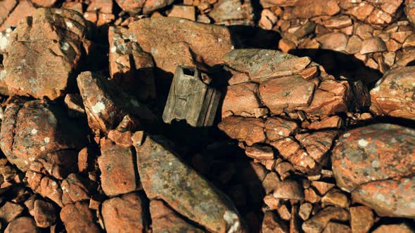 Old Rusty Metal Canister for Gasoline Fuel at Rocks