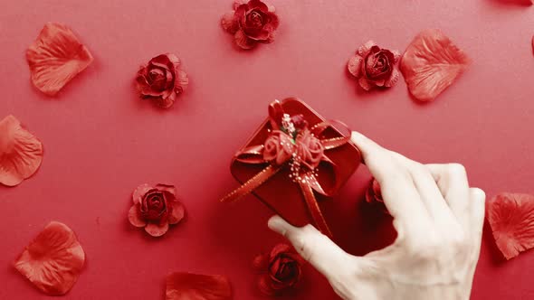 Red Gift with Petals Falling Down on the Background