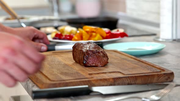 Man at Home Kitchen Slices Huge Juicy Steak Close Up. Meat Roasting Medium