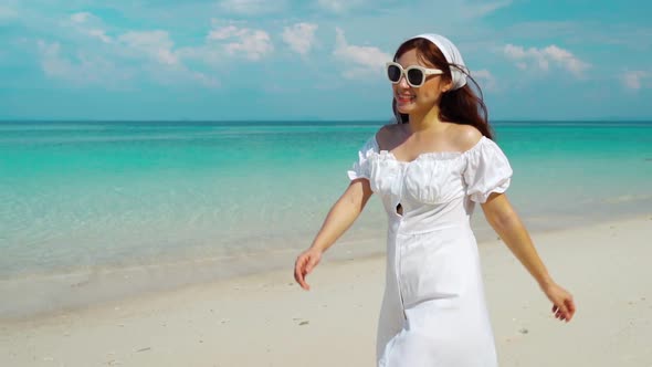 slow-motion of cheerful woman walking on the sea beach at Koh MunNork Island, Rayong, Thailand