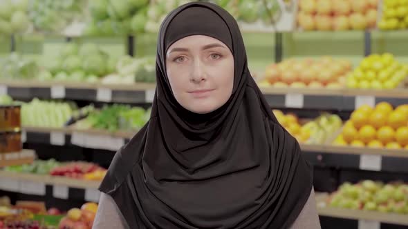 Portrait of Young Muslim Woman Standing in Grocery and Looking at Camera. Beautiful Girl in Hijab