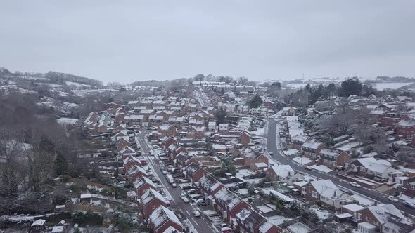 High sideways tracking drone shot of snowy Exeter subburbs