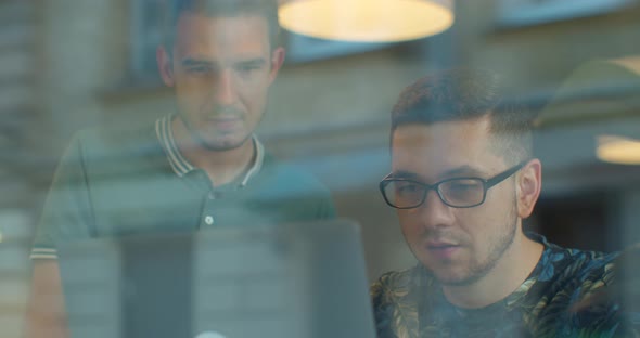 Shot of Two Young Male Office Employees or Colleagues Are Discussing and Working Together in Front