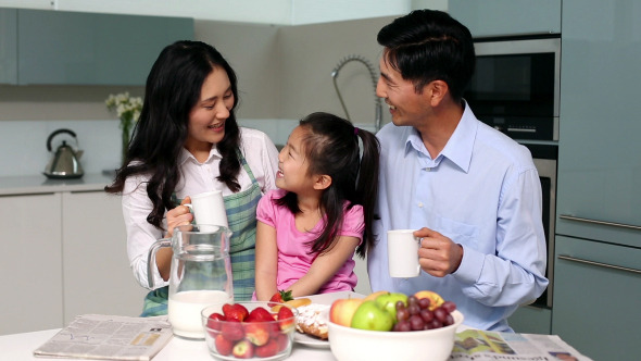 Happy Family Sitting At Breakfast Table