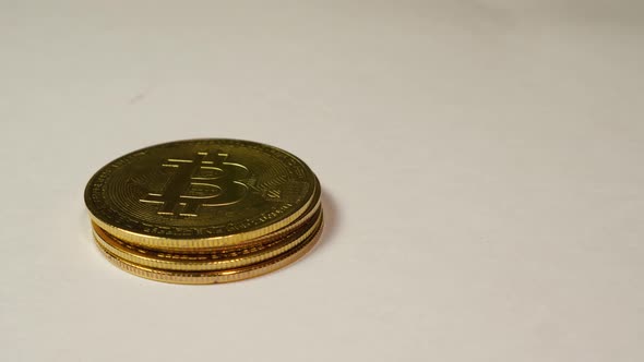 Close-up of male fingers stacking Bitcoin cryptocurrency coins in a column against