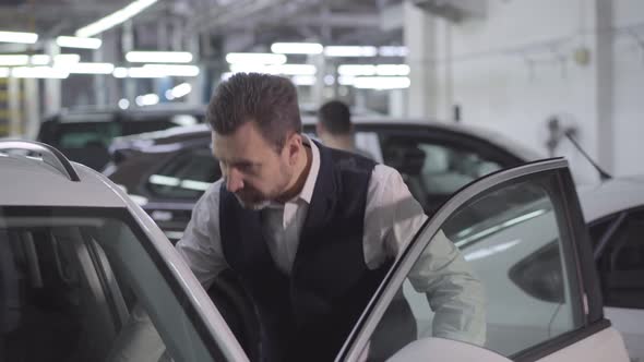 Portrait of Confident Caucasian Businessman Opening Car Door and Touching Automobile. Wealthy Man