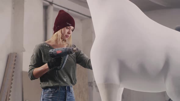 Craftswoman Drying Giraffe Statue in Workshop