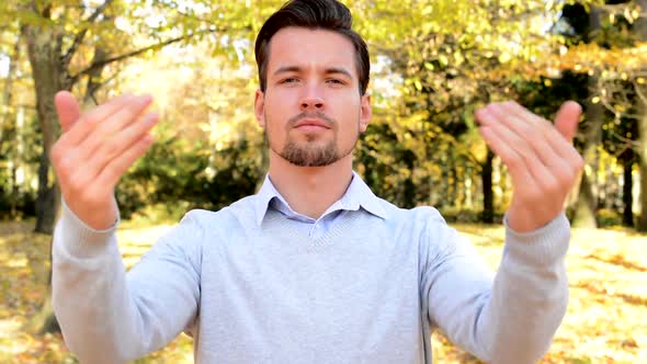 Young Handsome Man Stands in the Woods, Stare To Camera and with His Hands Shows To Oneself