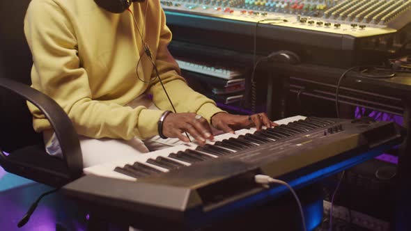 Black Man Playing Synthesizer in Recording Studio