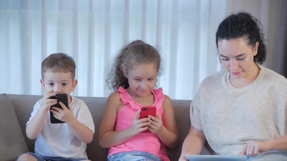 Happy Family,mom and Cute Little Kids,mother Playing with Children at Home Relaxing Use a Smartphone