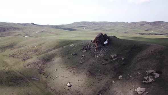 A Huge Rock on the Edge of a Green Hill