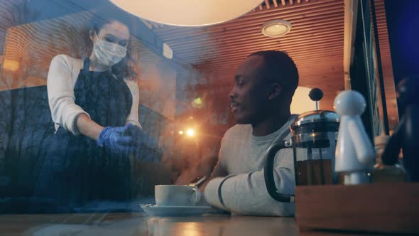 African Man Pays with Smart Watch in a Cafe During Pandemic