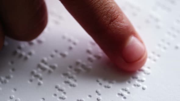 School kid reading a braille book in classroom at school