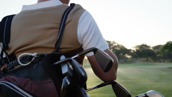 Golfer carrying his golf bag