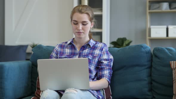 Young Woman Typing On Laptop in Office