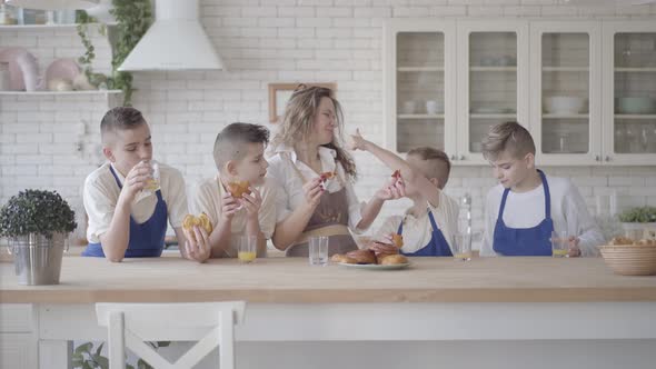 Portrait Attractive Happy Woman and Her Four Teen Sons Eating Pies and Drinking Orange Juice