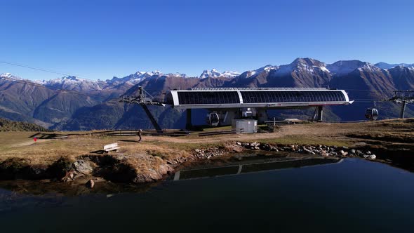 Hiker walking to gondola station in stunning Swiss alpine and lake panorama