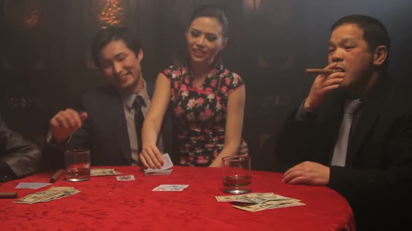 Female turning over winning card in black jack game