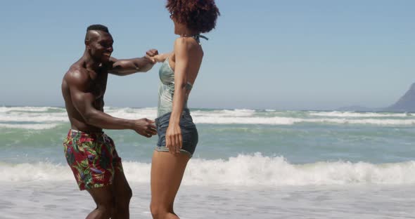 Couple dancing together on beach in the sunshine 4k