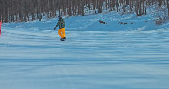 Snowboarder Makes a Tail Press a Professional Snowboard